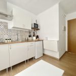 Cocina totalmente equipada con muebles blancos y detalles decorativos.