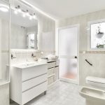 Baño moderno con plato de ducha, lavabo y espejo.