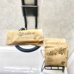 Paquete de jabones y gel de ducha de la marca Olive, presentados en un soporte de baño.